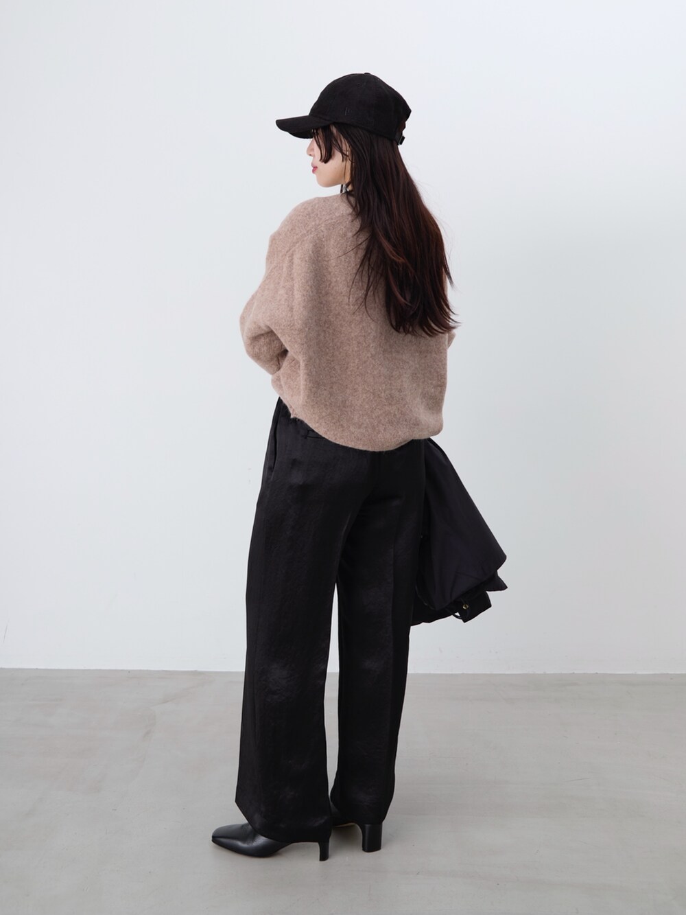 ブラック系のその他パンツ、ブラック系のダウンジャケット/コート、ブラウン系のニット/セーターを着用したレディースの冬コーディネートの4枚目の写真