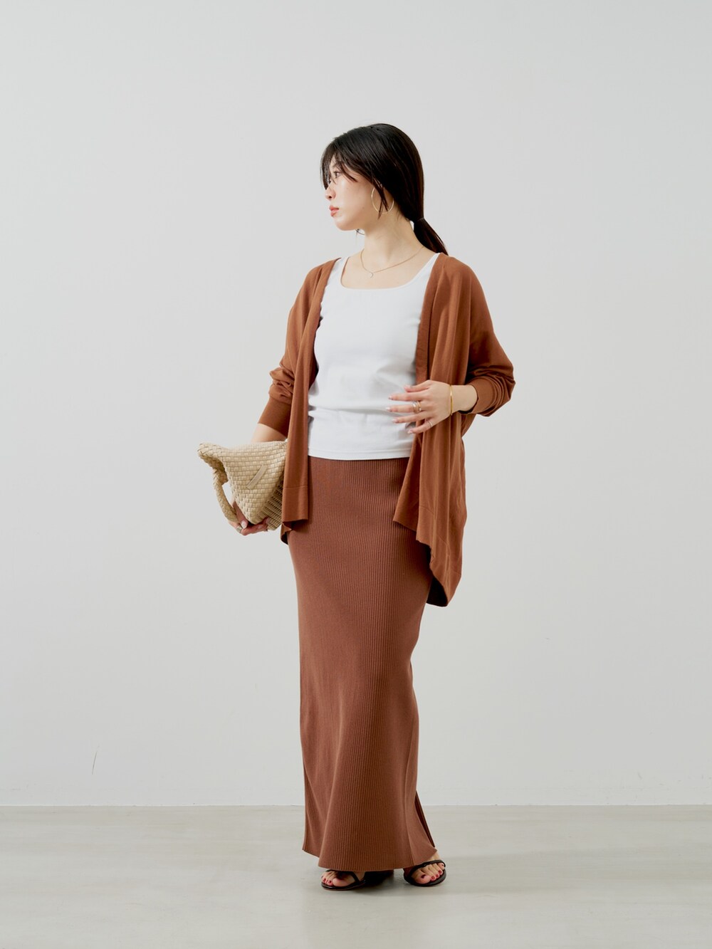 ブラウン系のカーディガン/ボレロ、ホワイト系のタンクトップ、ベージュ系のトートバッグを着用したレディースの夏コーディネートの2枚目の写真