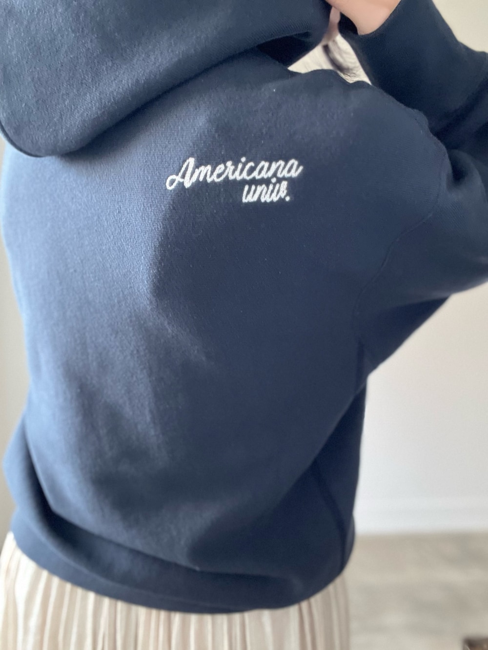 ブラック系のパーカー、ベージュ系のスカートを着用したレディースの秋コーディネートの9枚目の写真