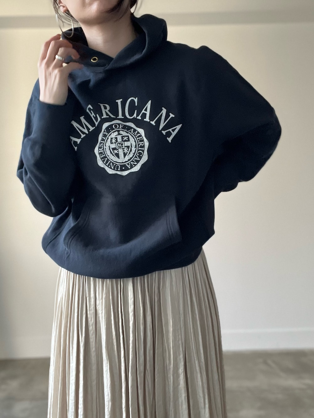 ブラック系のパーカー、ベージュ系のスカートを着用したレディースの秋コーディネートの5枚目の写真