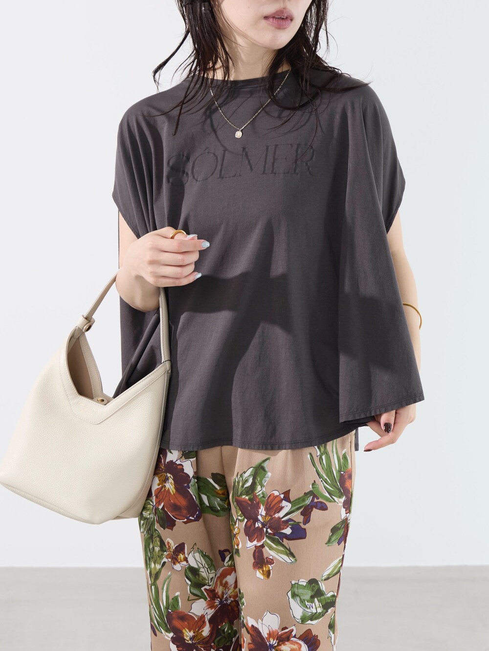 グレー系のTシャツ/カットソー、ベージュ系のその他パンツ、ホワイト系のハンドバッグを着用したレディースの夏コーディネートの8枚目の写真