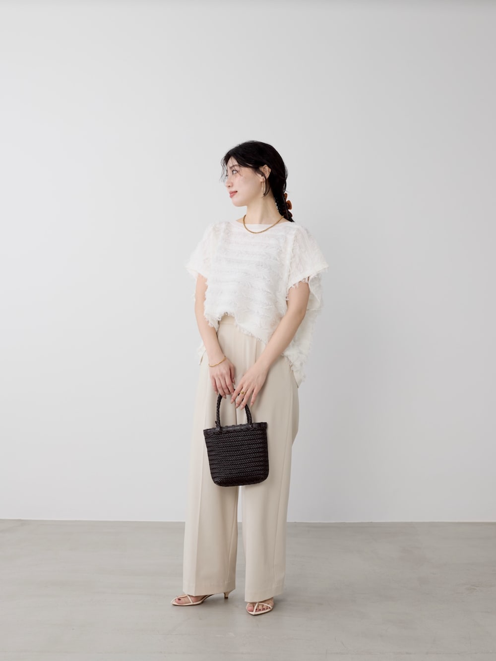 ベージュ系のその他パンツ、ホワイト系のニット/セーターを着用したレディースの春コーディネートの2枚目の写真