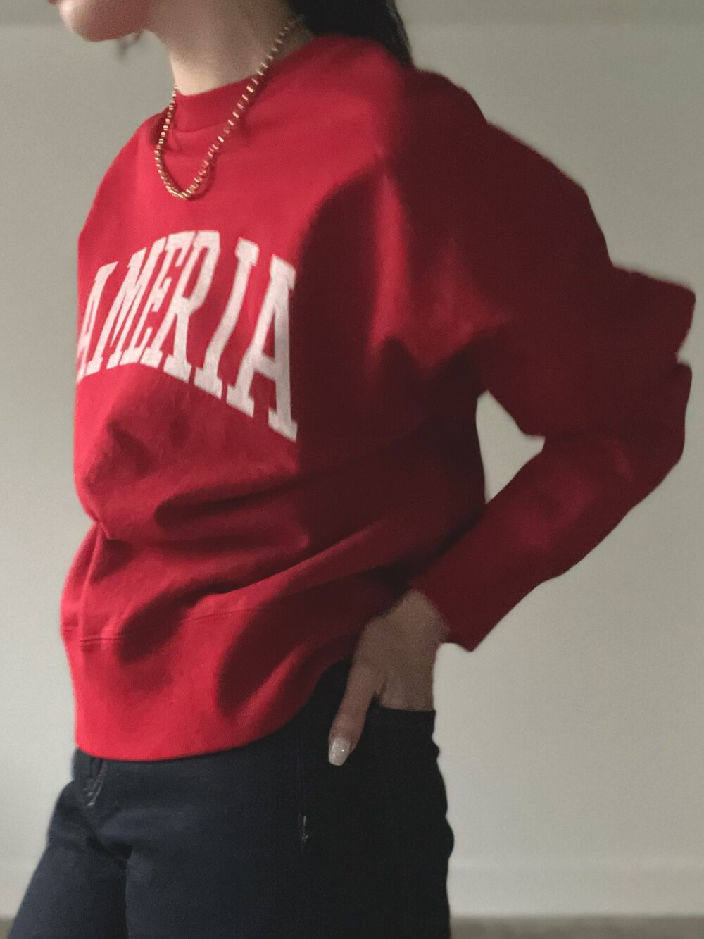 レッド系のスウェットを着用したレディースの秋コーディネートの3枚目の写真