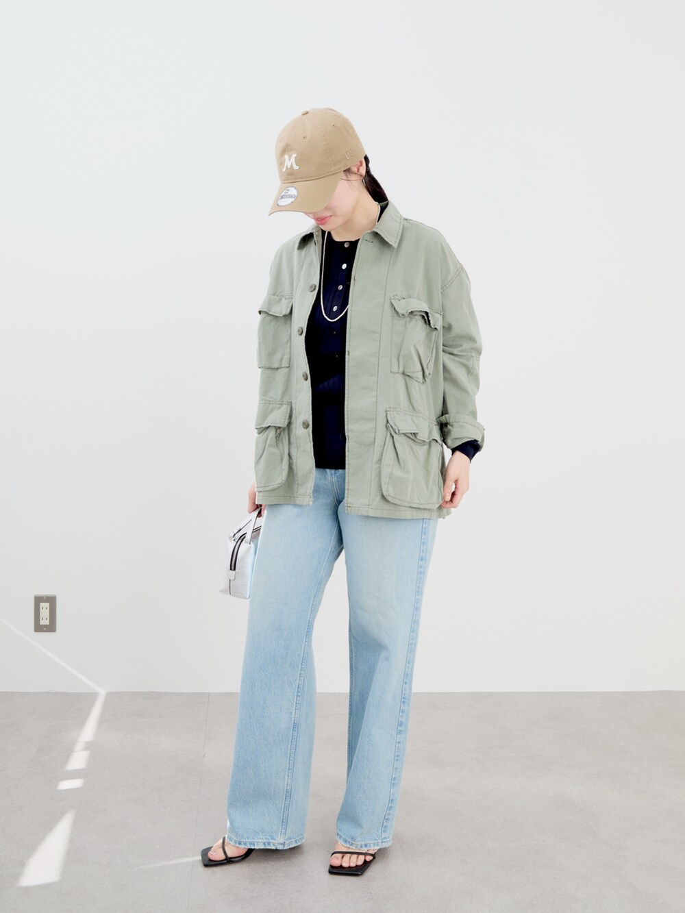 ブルー系のニット/セーター、グリーン系のシャツ/ブラウス、ベージュ系のキャップを着用したレディースの冬コーディネートの3枚目の写真