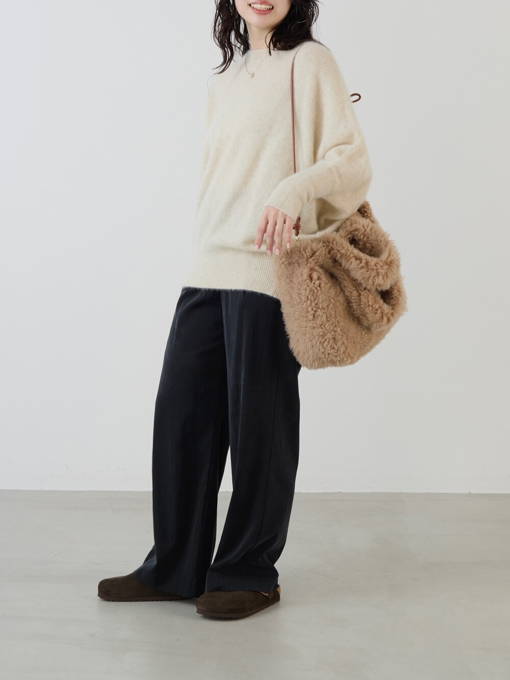 ベージュ系のハンドバッグ、ブラック系のその他パンツ、ホワイト系のニット/セーターを着用したレディースの秋コーディネートの4枚目の写真