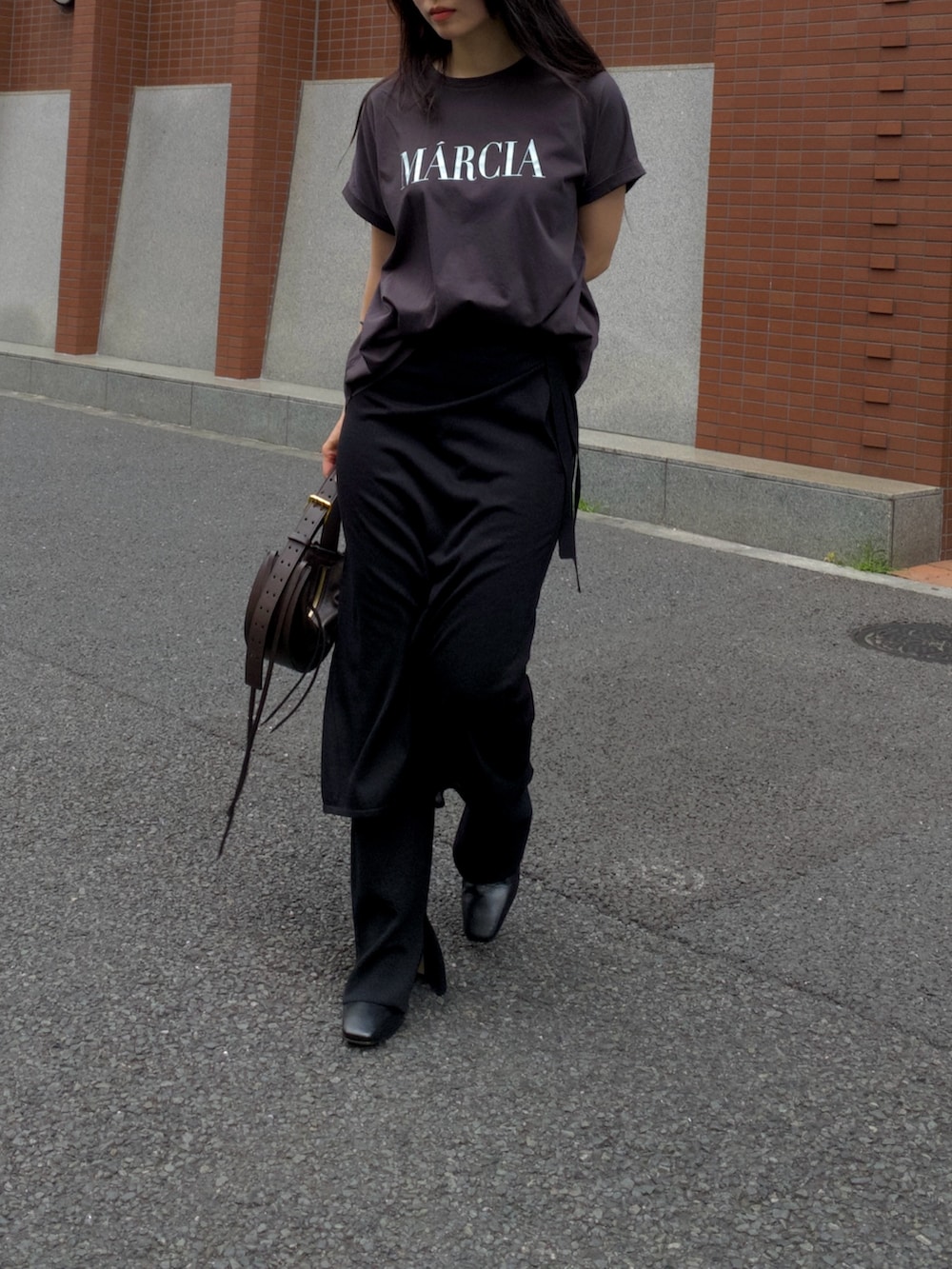 ブラック系のTシャツ/カットソーを着用したレディースの夏コーディネートの2枚目の写真