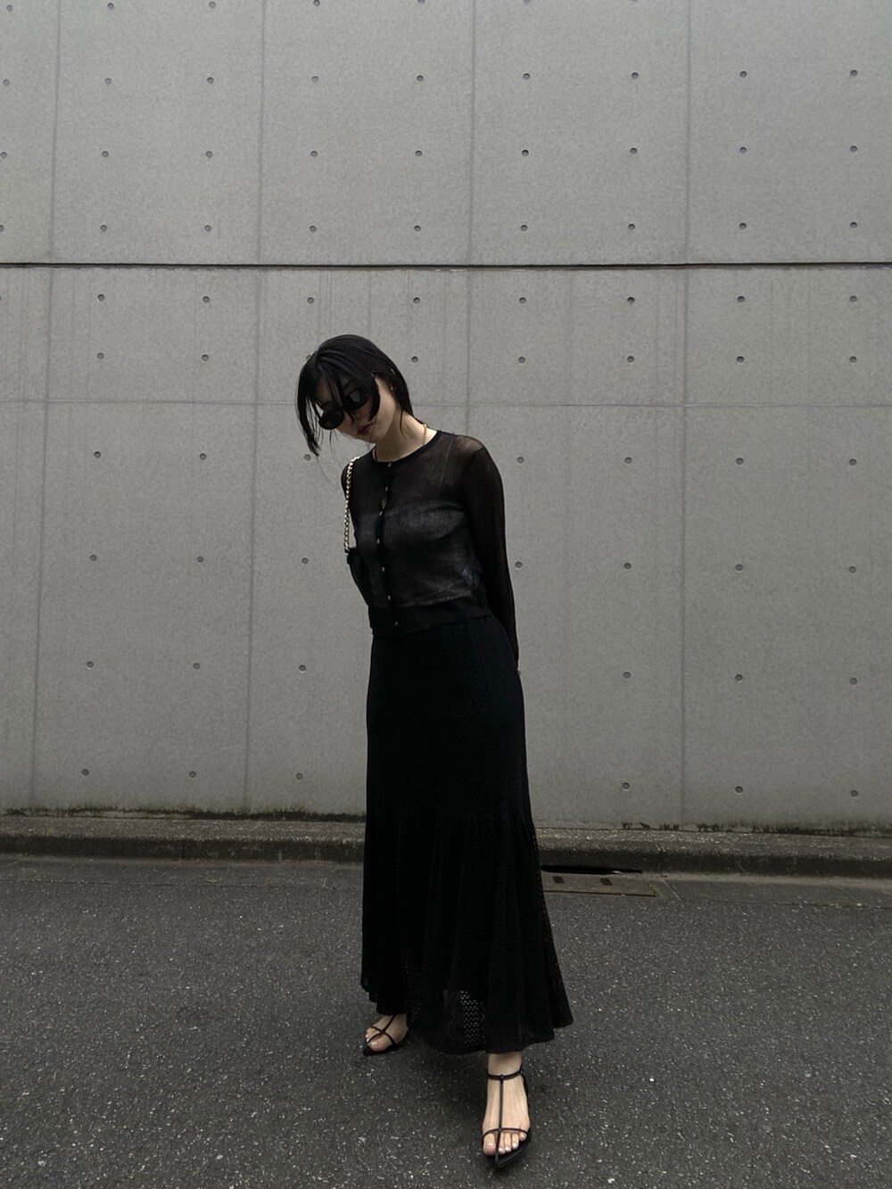 ブラック系のカーディガン/ボレロ、ブラック系のショルダーバッグ、ブラック系のスカートを着用したレディースの春コーディネートの2枚目の写真