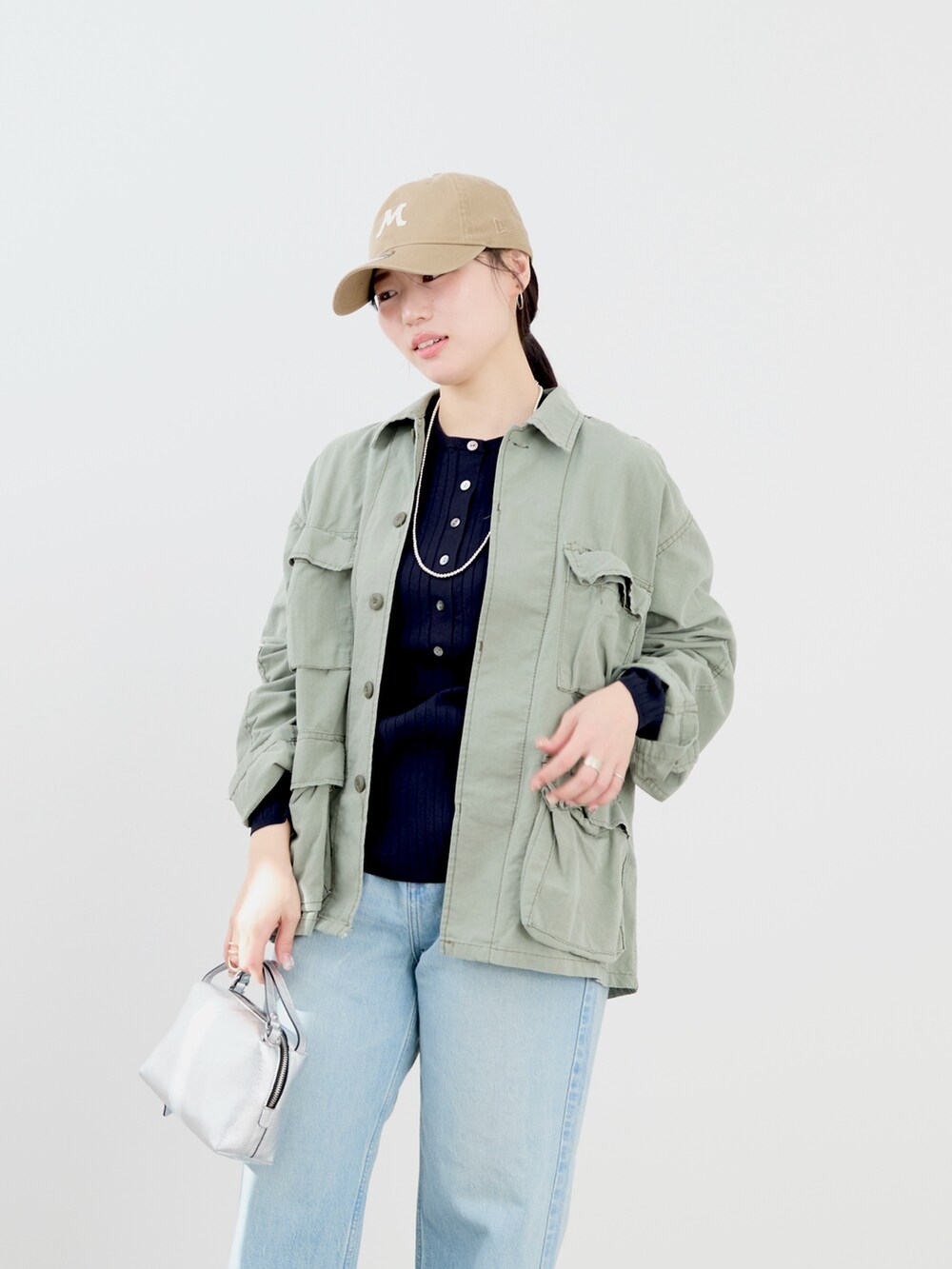 ブルー系のニット/セーター、グリーン系のシャツ/ブラウス、ベージュ系のキャップを着用したレディースの冬コーディネートの7枚目の写真