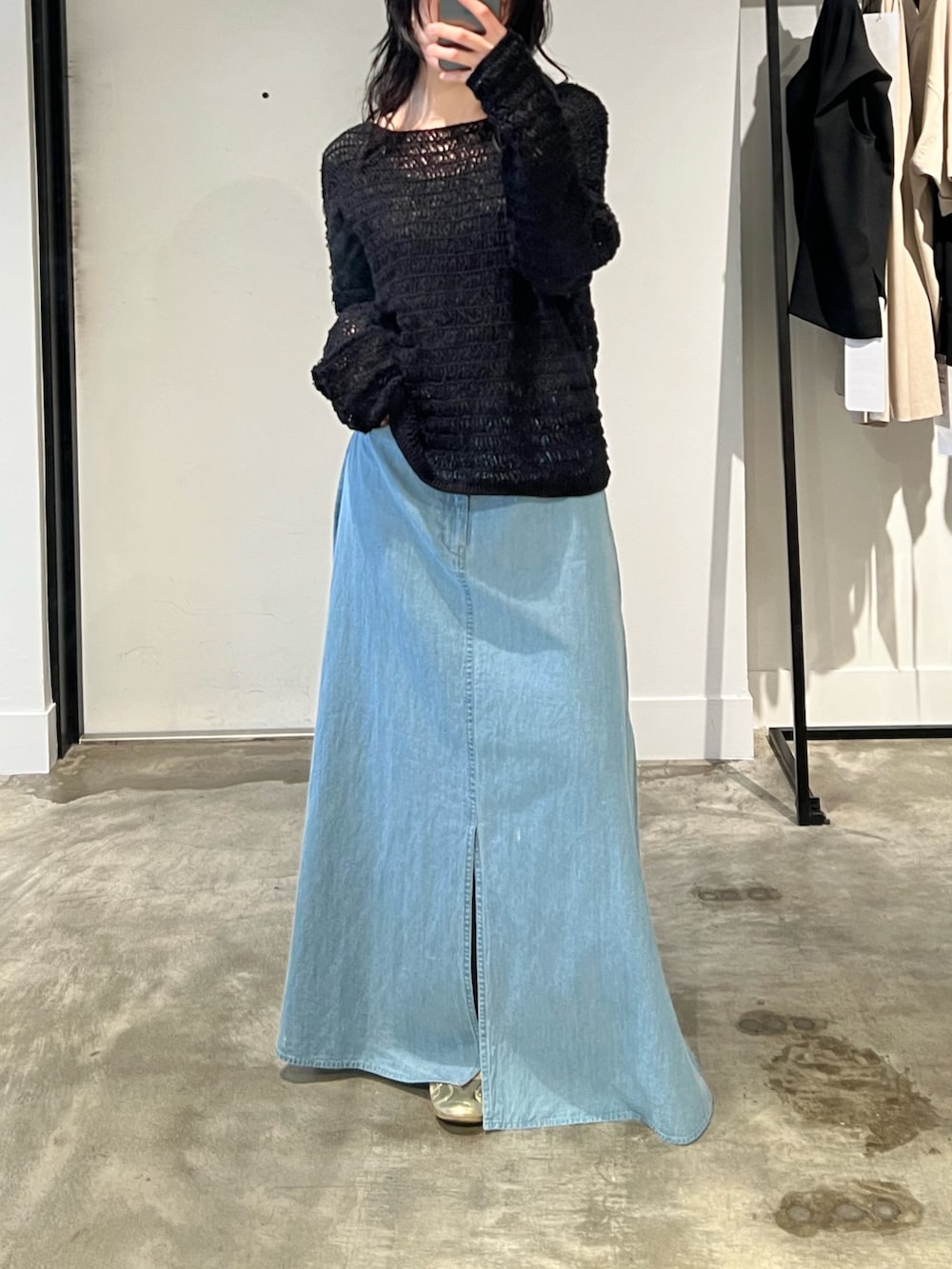 ブラック系のニット/セーター、ブルー系のスカートを着用したレディースの春コーディネートの5枚目の写真