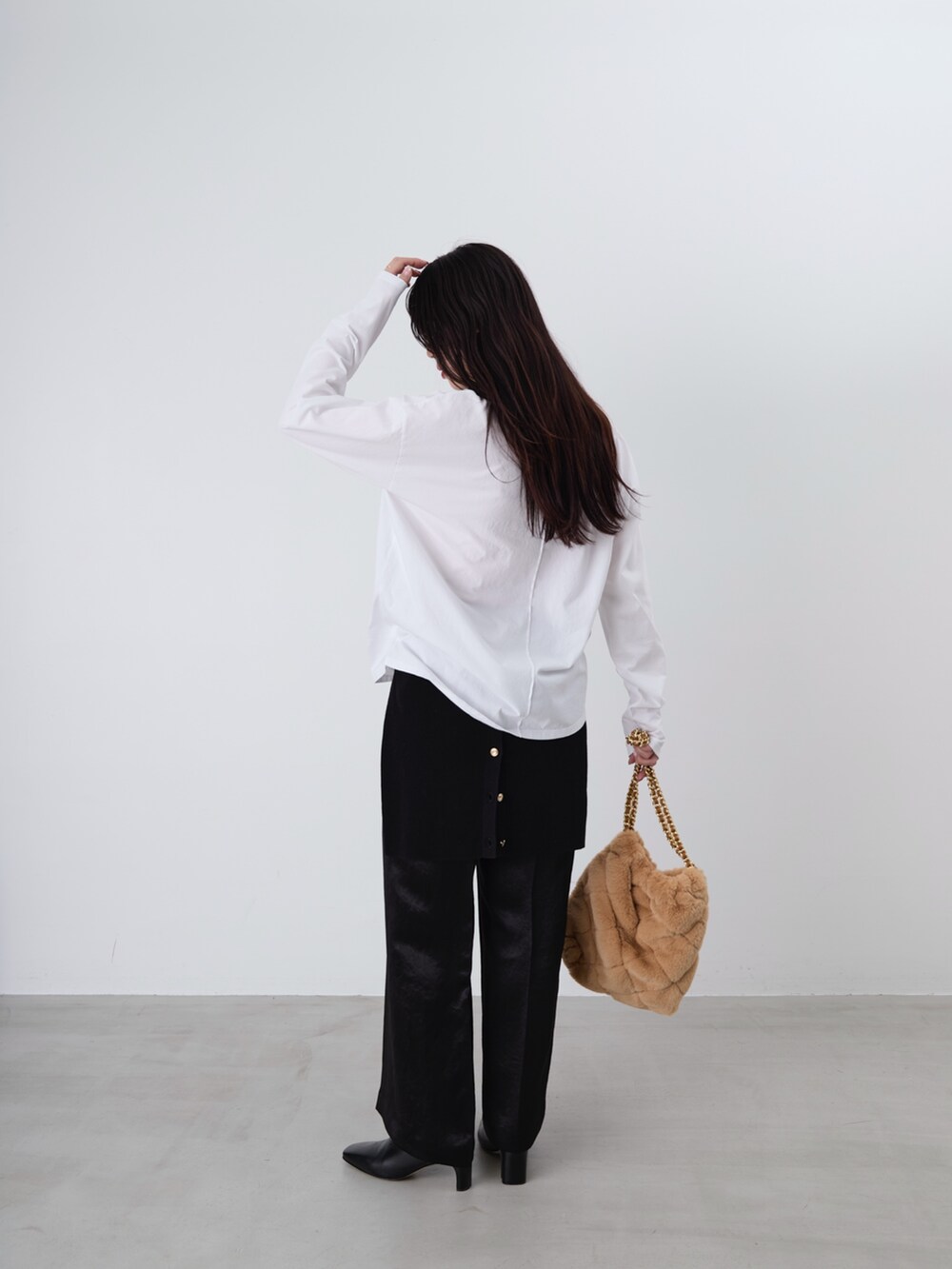 ベージュ系のショルダーバッグ、ホワイト系のTシャツ/カットソー、ブラック系のカーディガン/ボレロを着用したレディースの冬コーディネートの5枚目の写真