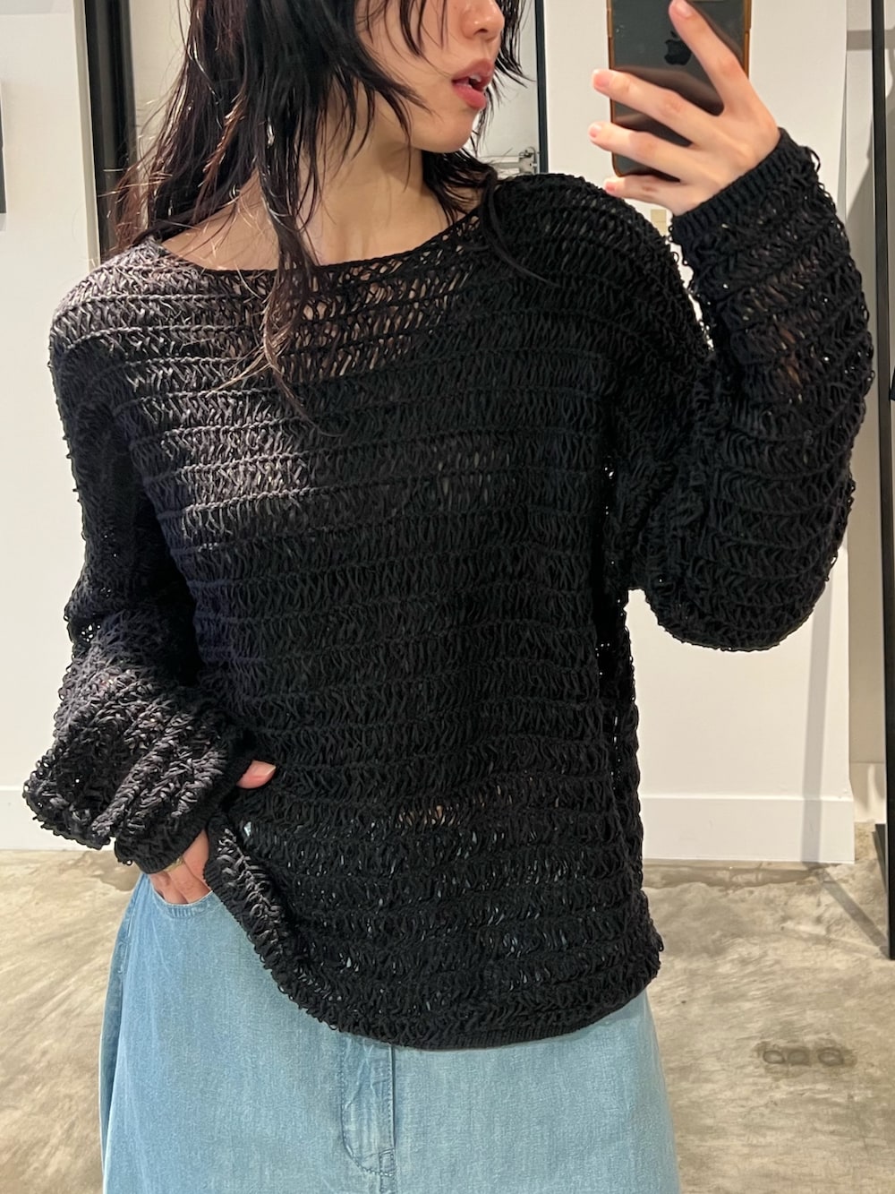 ブラック系のニット/セーター、ブルー系のスカートを着用したレディースの春コーディネートの4枚目の写真