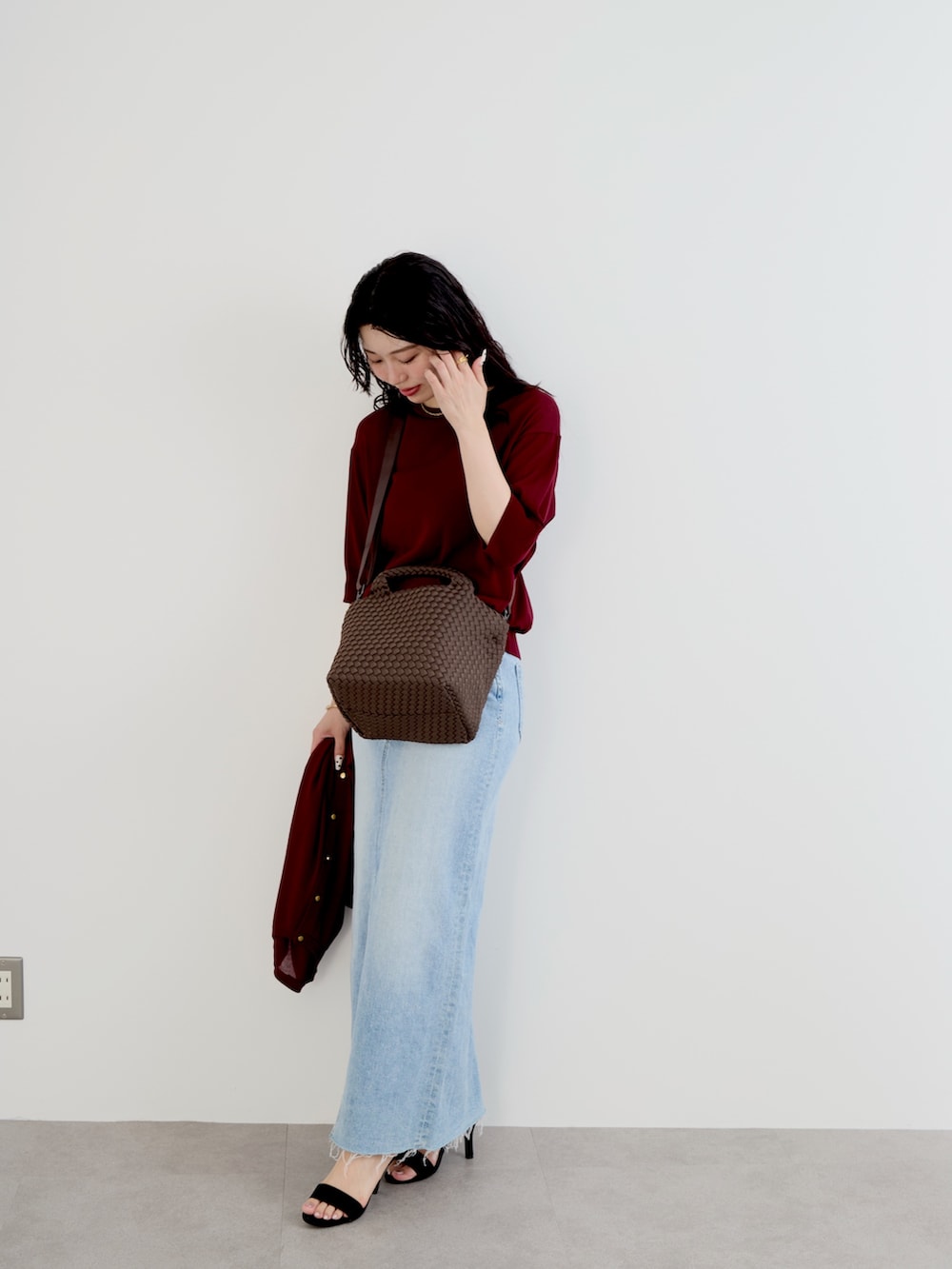 ホワイト系のニット/セーター、ブラウン系のトートバッグ、ホワイト系のカーディガン/ボレロを着用したレディースの夏コーディネートの2枚目の写真