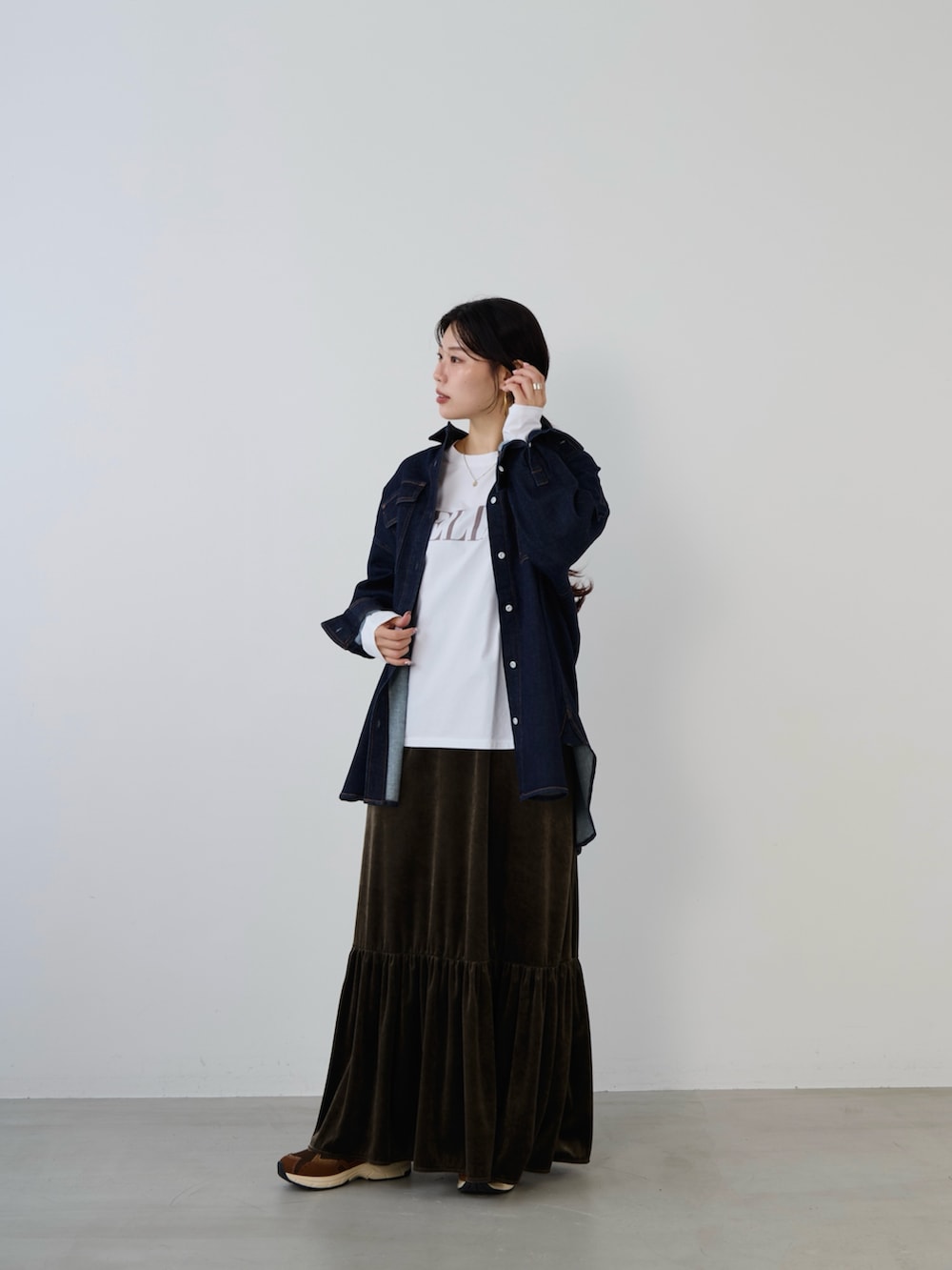 ベージュ系のTシャツ/カットソー、ブルー系のシャツ/ブラウス、ブラウン系のスニーカーを着用したレディースの秋コーディネートの2枚目の写真