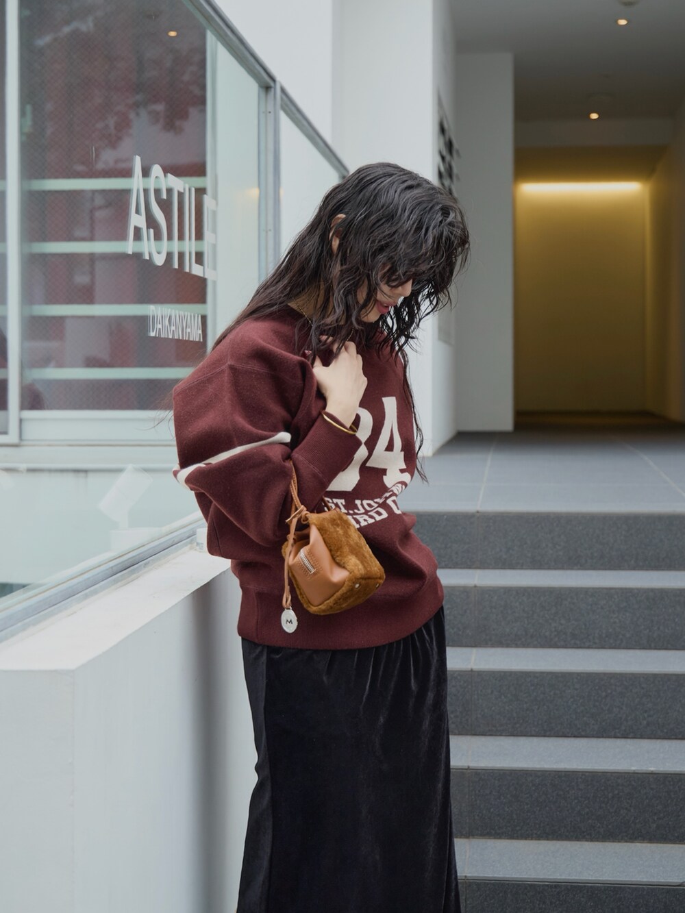 ブラック系のスカート、イエロー系のハンドバッグ、ブラウン系のニット/セーターを着用したレディースの秋コーディネートの5枚目の写真