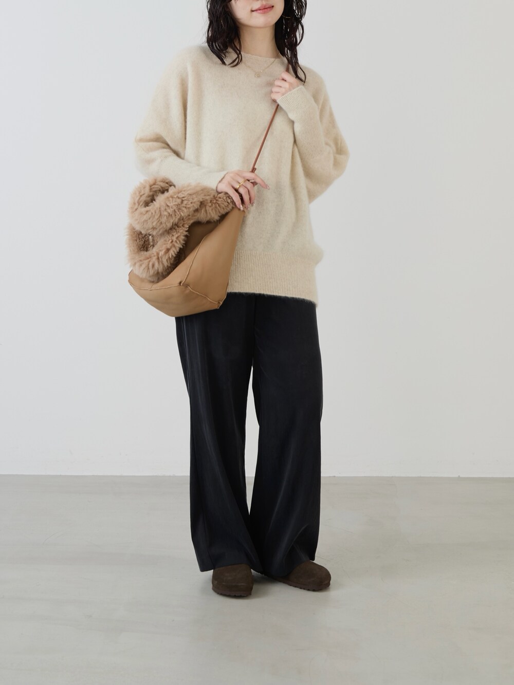ベージュ系のハンドバッグ、ブラック系のその他パンツ、ホワイト系のニット/セーターを着用したレディースの秋コーディネートの3枚目の写真