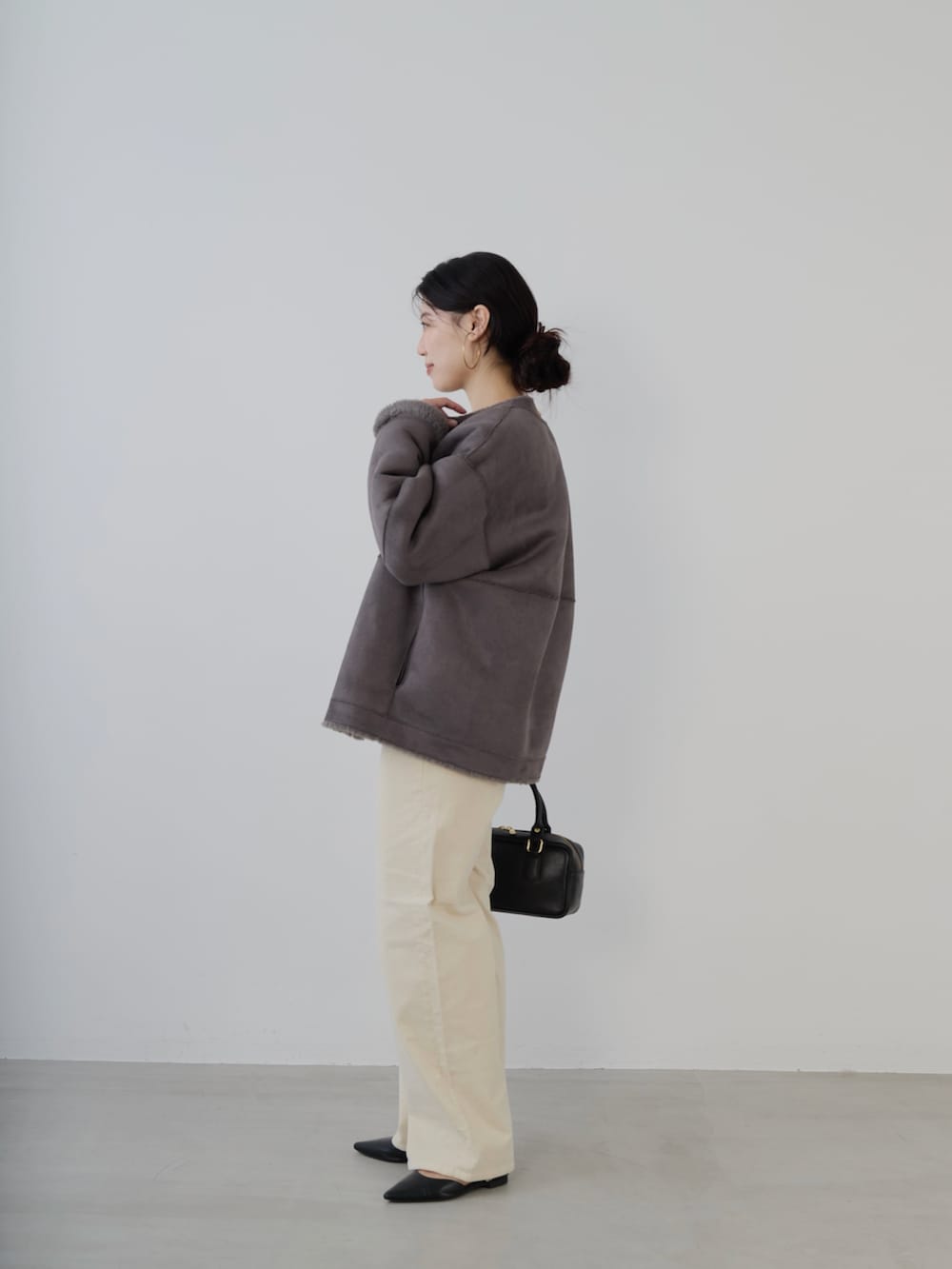 ブラック系のボストンバッグ、レッド系のニット/セーター、グレー系のノーカラーコートを着用したレディースの秋コーディネートの3枚目の写真