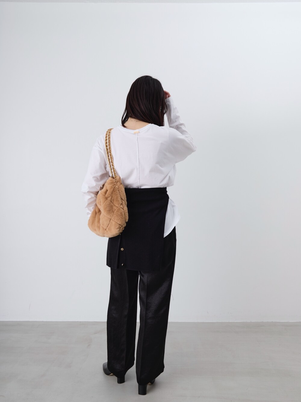 ベージュ系のショルダーバッグ、ホワイト系のTシャツ/カットソー、ブラック系のカーディガン/ボレロを着用したレディースの冬コーディネートの7枚目の写真