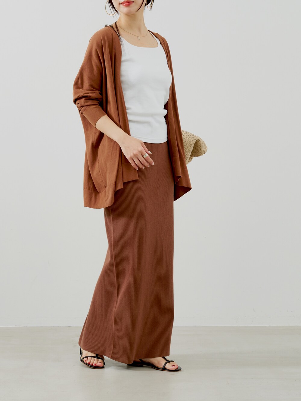 ブラウン系のカーディガン/ボレロ、ホワイト系のタンクトップ、ベージュ系のトートバッグを着用したレディースの夏コーディネートの3枚目の写真