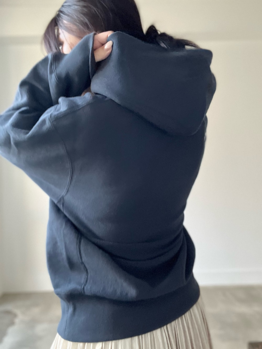 ブラック系のパーカー、ベージュ系のスカートを着用したレディースの秋コーディネートの8枚目の写真