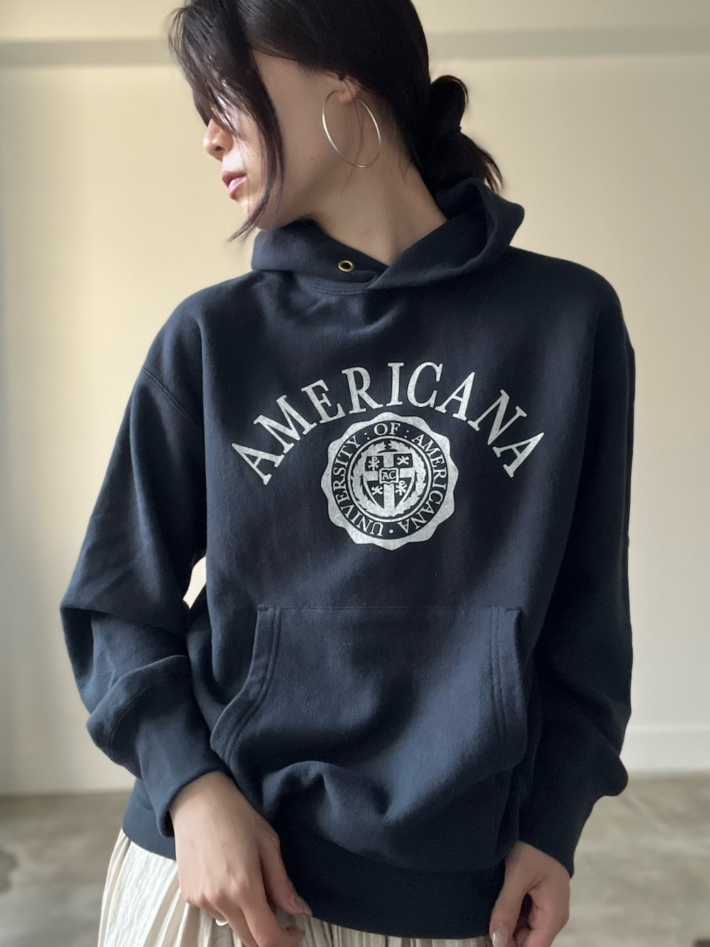 ブラック系のパーカー、ベージュ系のスカートを着用したレディースの秋コーディネートの7枚目の写真