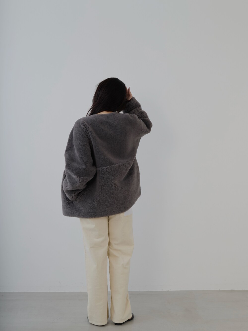 ブラック系のボストンバッグ、レッド系のニット/セーター、グレー系のノーカラーコートを着用したレディースの秋コーディネートの5枚目の写真