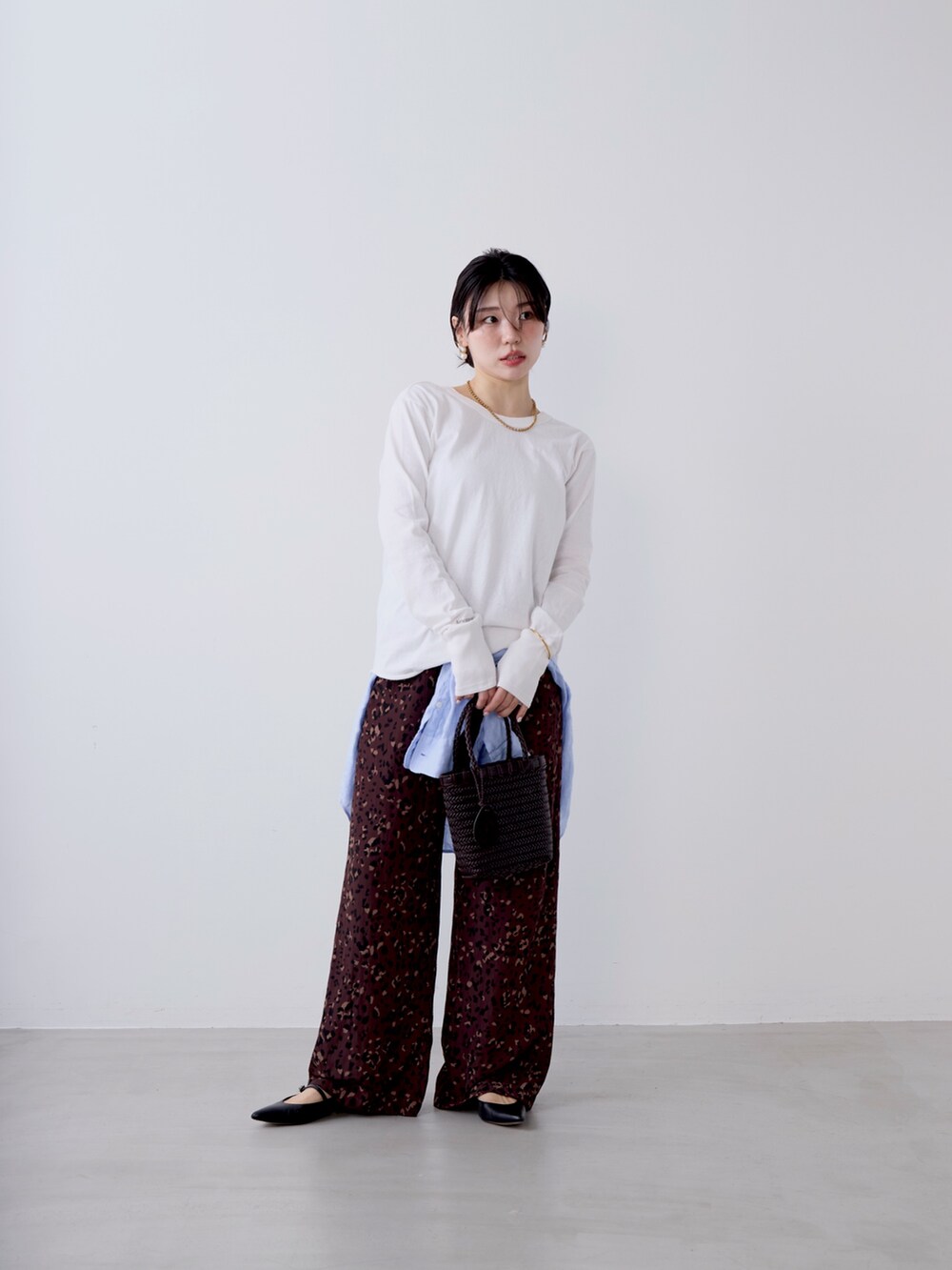 ホワイト系のTシャツ/カットソー、ブラウン系のその他パンツ、ブルー系のシャツ/ブラウスを着用したレディースの冬コーディネートの2枚目の写真