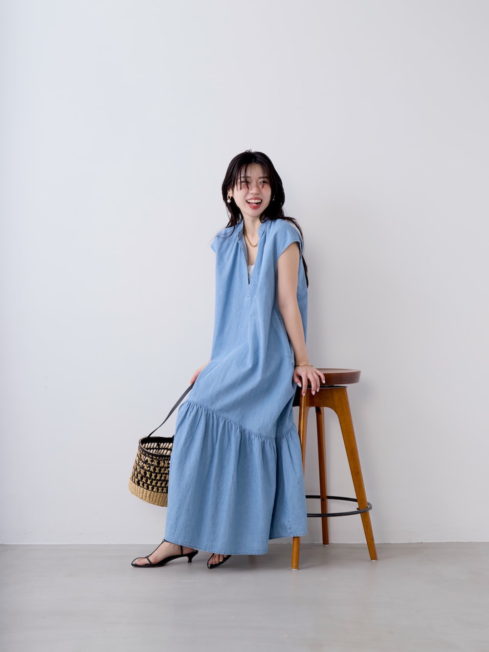 ブルー系のワンピースを着用したレディースの春コーディネートの2枚目の写真