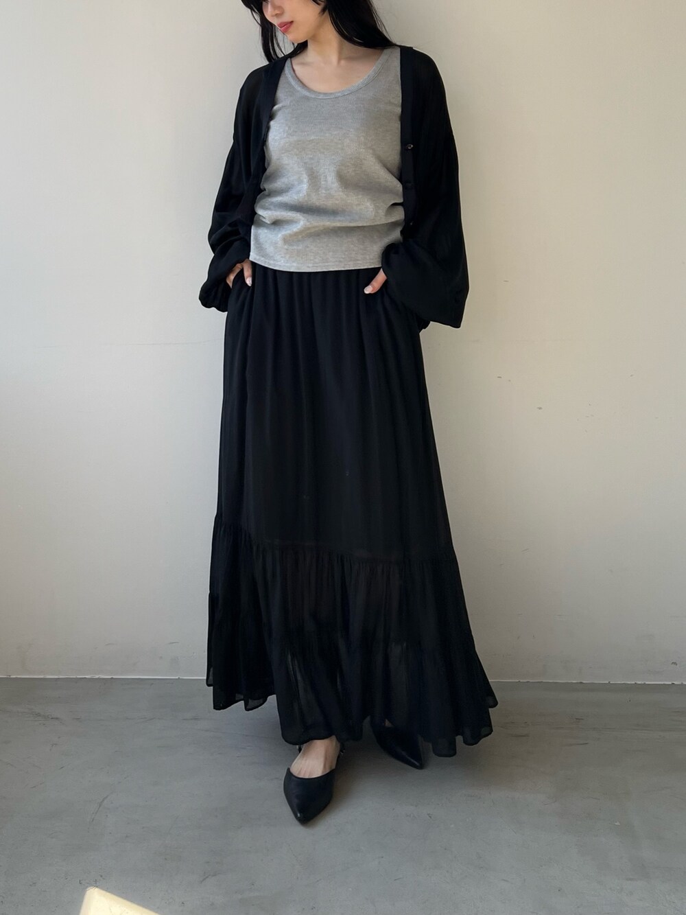 ブラック系のスカート、シルバー系のタンクトップ、ブラック系のカーディガン/ボレロを着用したレディースの春コーディネートの3枚目の写真