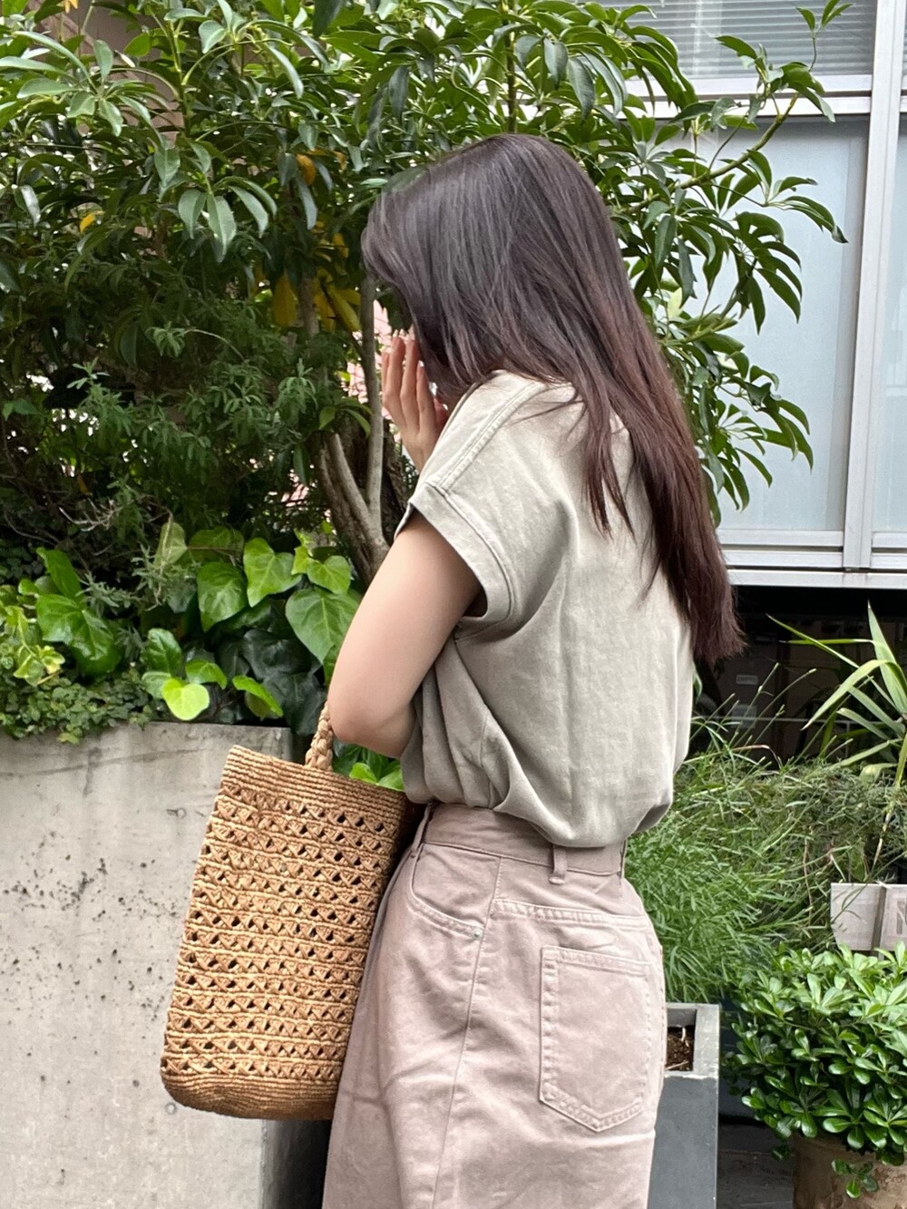 ベージュ系のデニムパンツ、ベージュ系のTシャツ/カットソー、ブラウン系のハンドバッグを着用したレディースの夏コーディネートの7枚目の写真