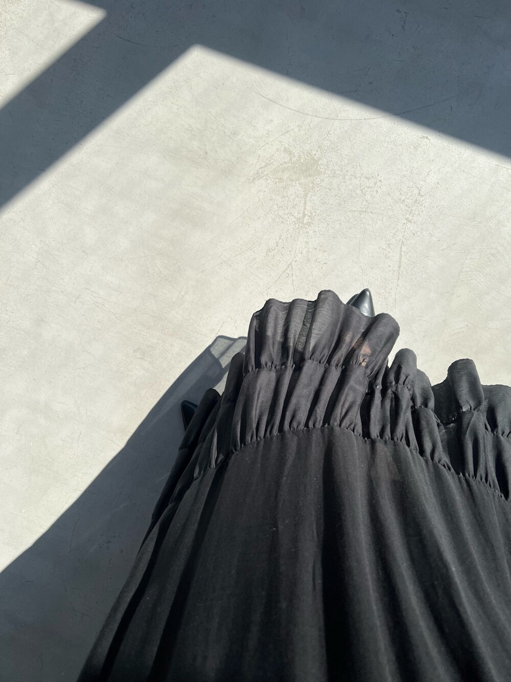 ブラック系のスカート、シルバー系のタンクトップ、ブラック系のカーディガン/ボレロを着用したレディースの春コーディネートの7枚目の写真