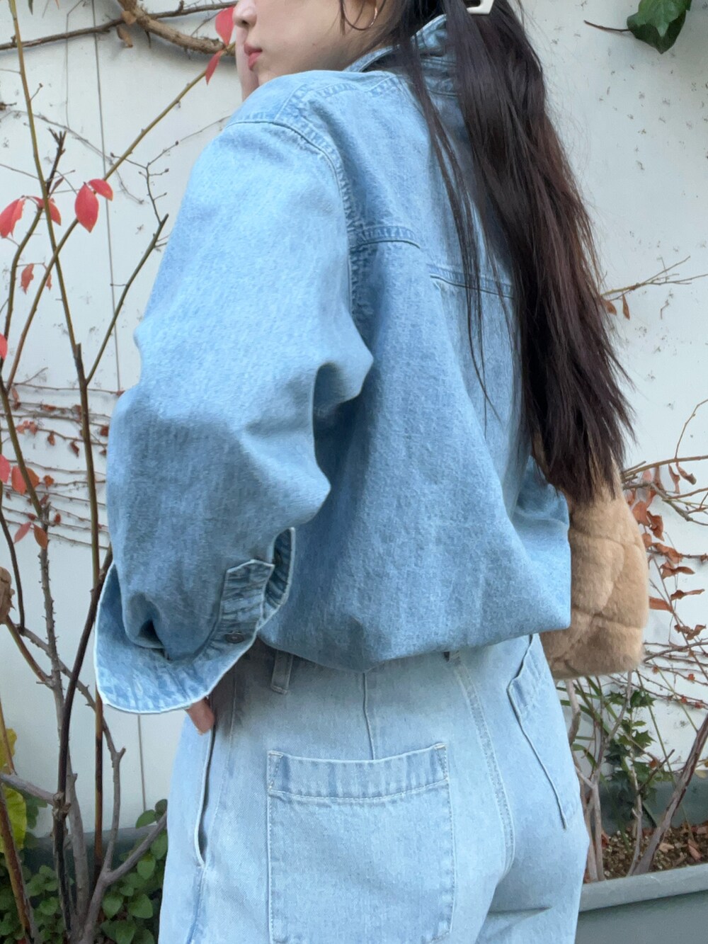 ベージュ系のショルダーバッグ、ブルー系のデニムパンツ、ブルー系のシャツ/ブラウスを着用したレディースの冬コーディネートの4枚目の写真