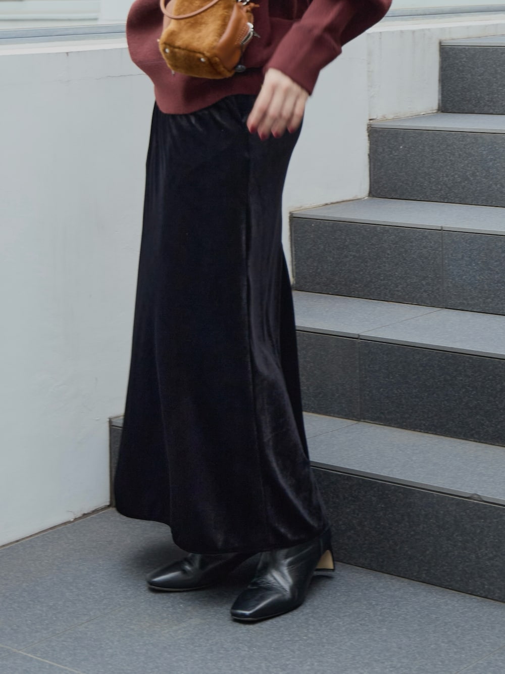 ブラック系のスカート、イエロー系のハンドバッグ、ブラウン系のニット/セーターを着用したレディースの秋コーディネートの3枚目の写真