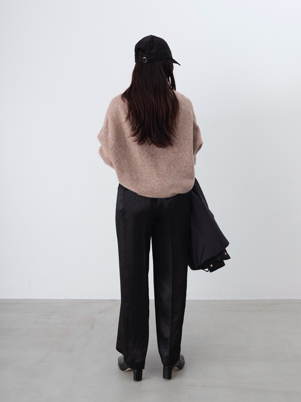 ブラック系のその他パンツ、ブラック系のダウンジャケット/コート、ブラウン系のニット/セーターを着用したレディースの冬コーディネートの5枚目の写真
