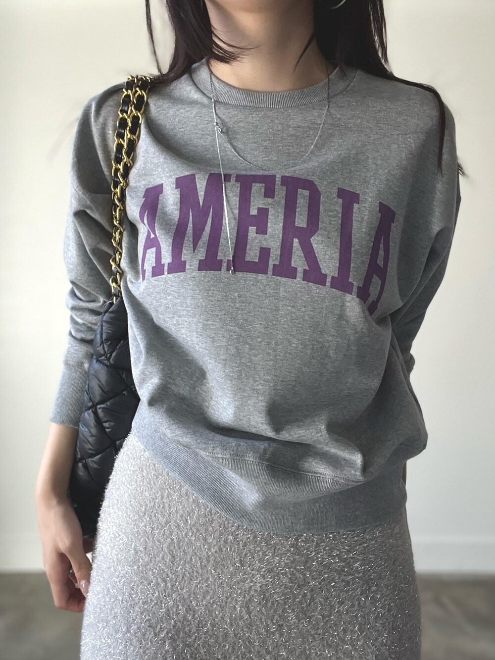 グレー系のスウェット、ベージュ系のスカートを着用したレディースの秋コーディネートの3枚目の写真