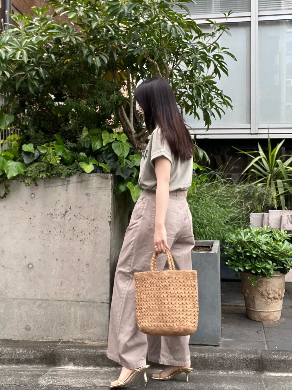 ベージュ系のデニムパンツ、ベージュ系のTシャツ/カットソー、ブラウン系のハンドバッグを着用したレディースの夏コーディネートの4枚目の写真