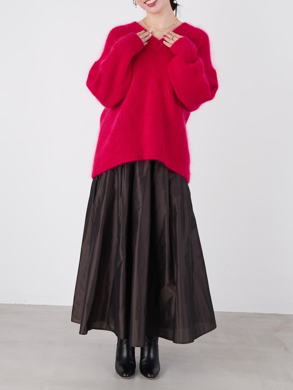 ピンク系のニット/セーター、ブラック系のスカートを着用したレディースの冬コーディネートの2枚目の写真