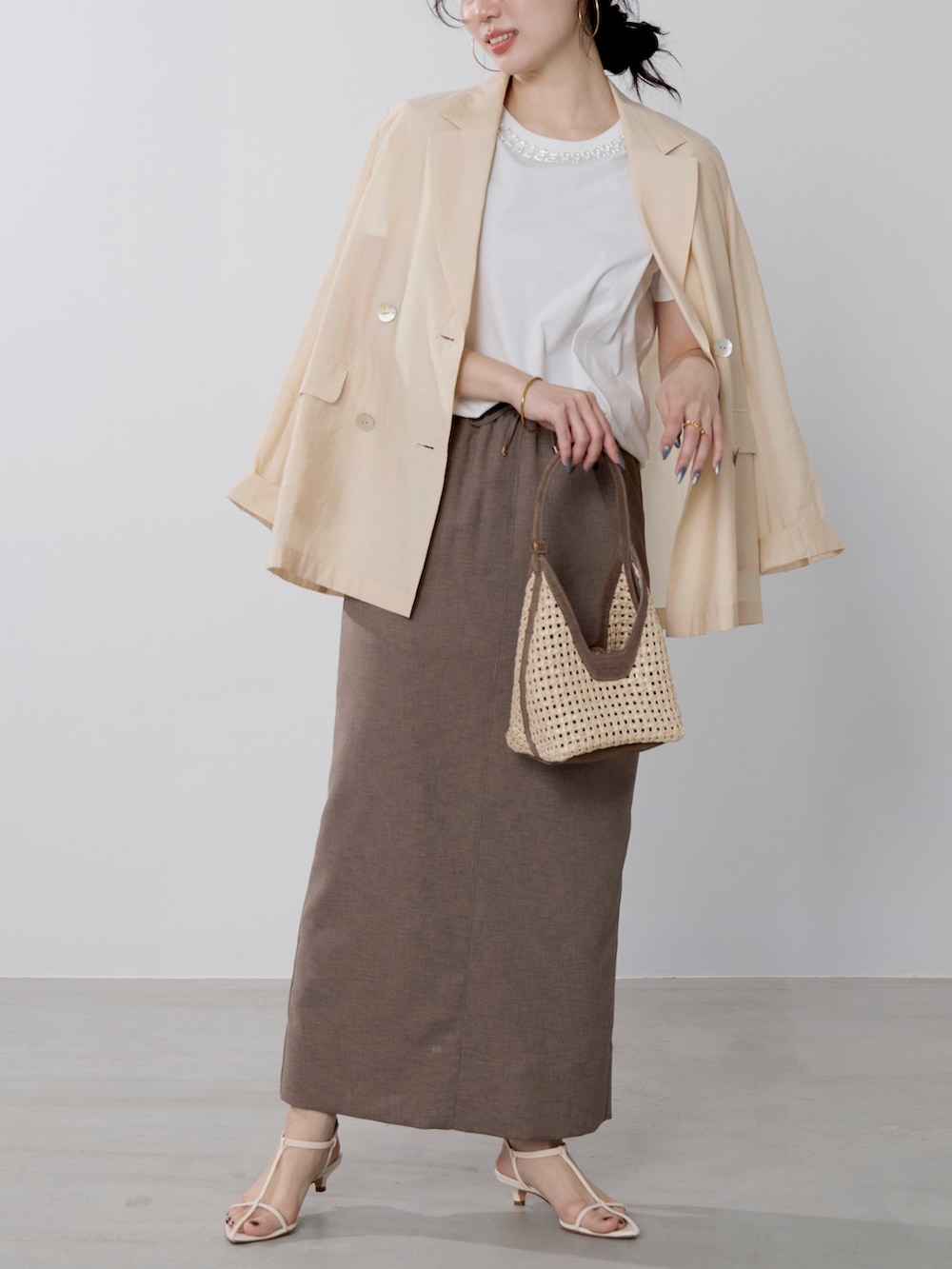ホワイト系のTシャツ/カットソー、ブラウン系のハンドバッグ、ベージュ系のテーラードジャケットを着用したレディースの春コーディネートの4枚目の写真