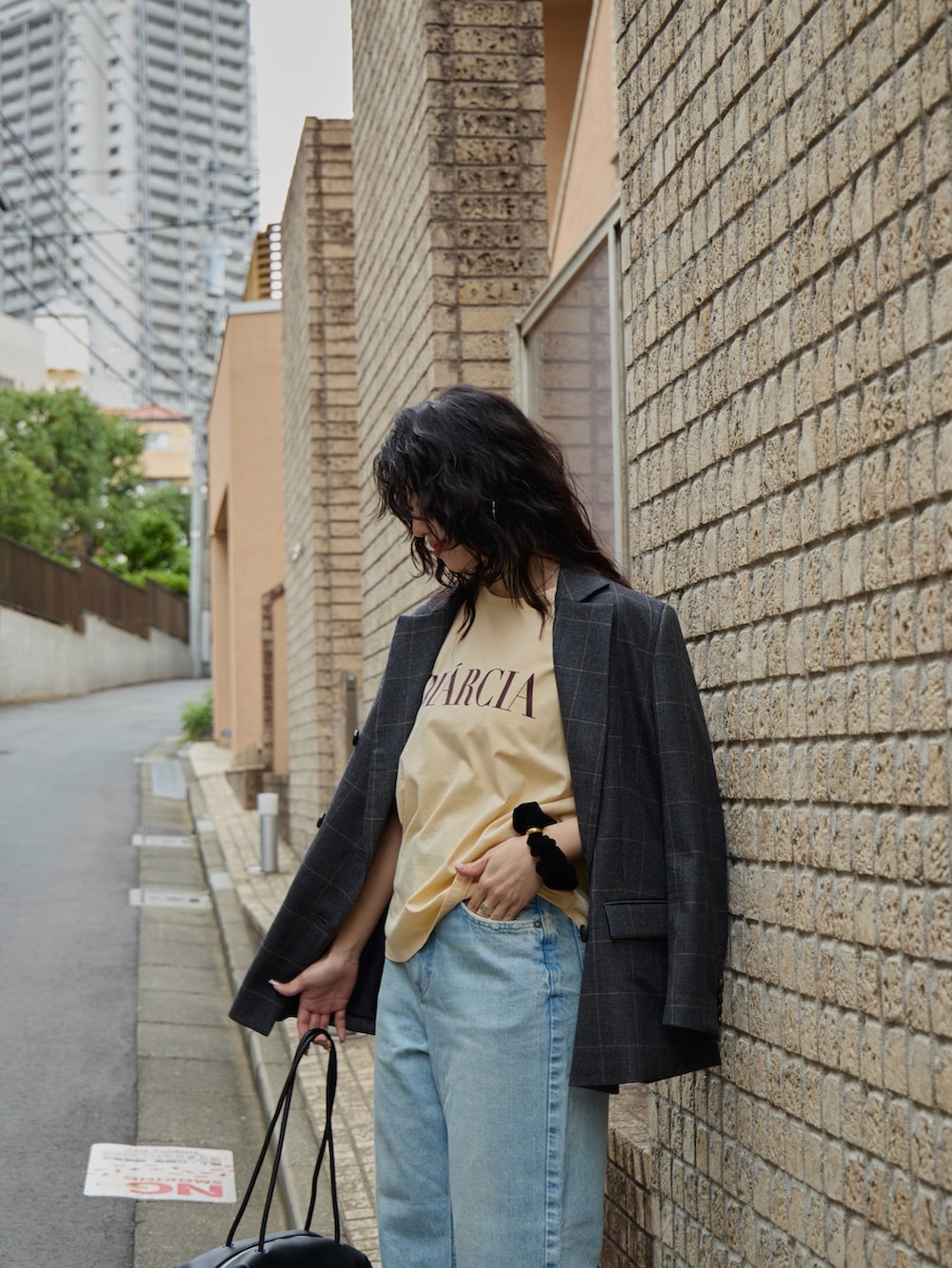 グレー系のテーラードジャケット、オレンジ系のTシャツ/カットソー、ブラック系のボストンバッグを着用したレディースの秋コーディネートの5枚目の写真