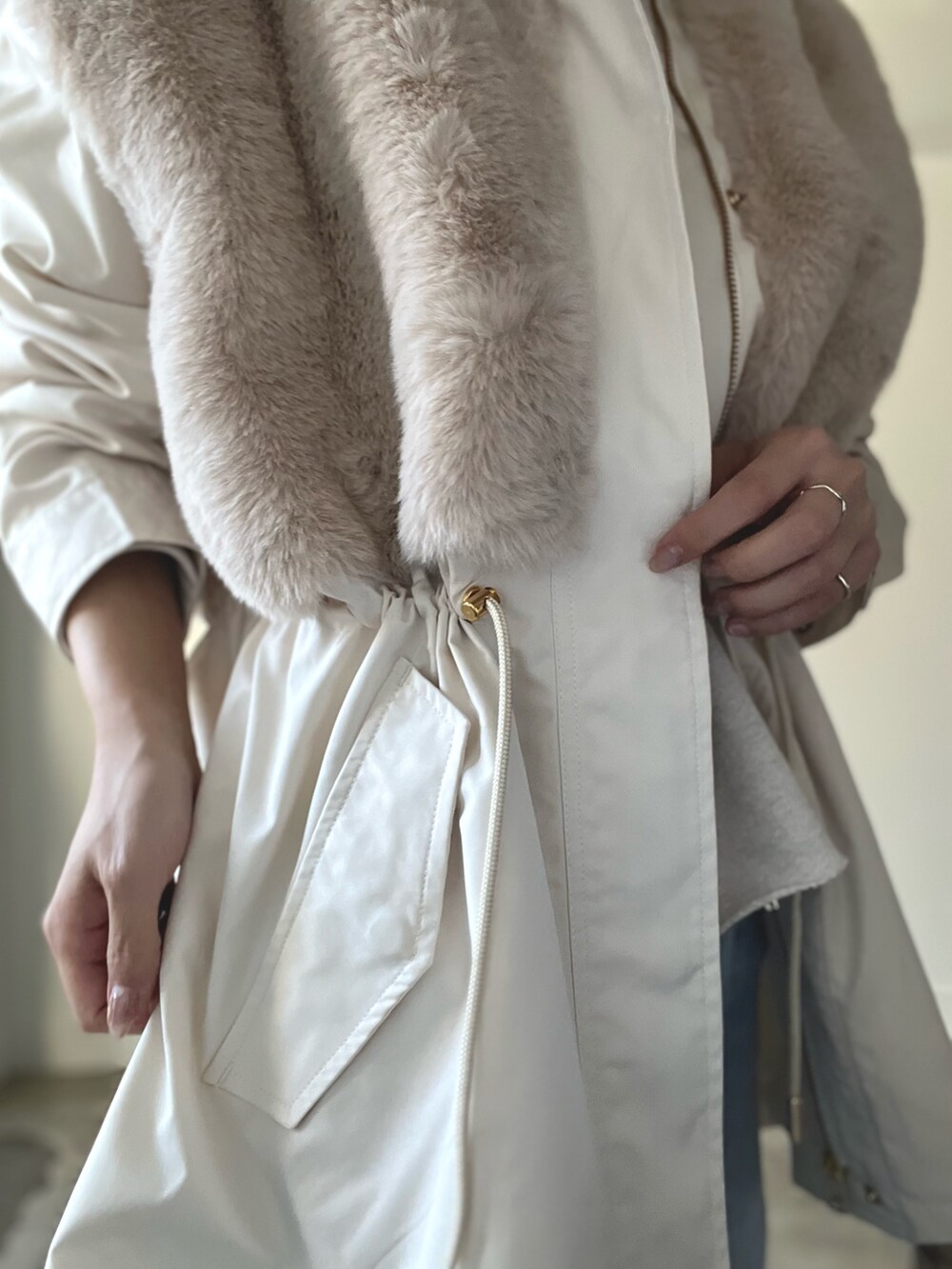 ベージュ系のブルゾン、ブルー系のデニムパンツ、グリーン系のキャップを着用したレディースの秋コーディネートの3枚目の写真