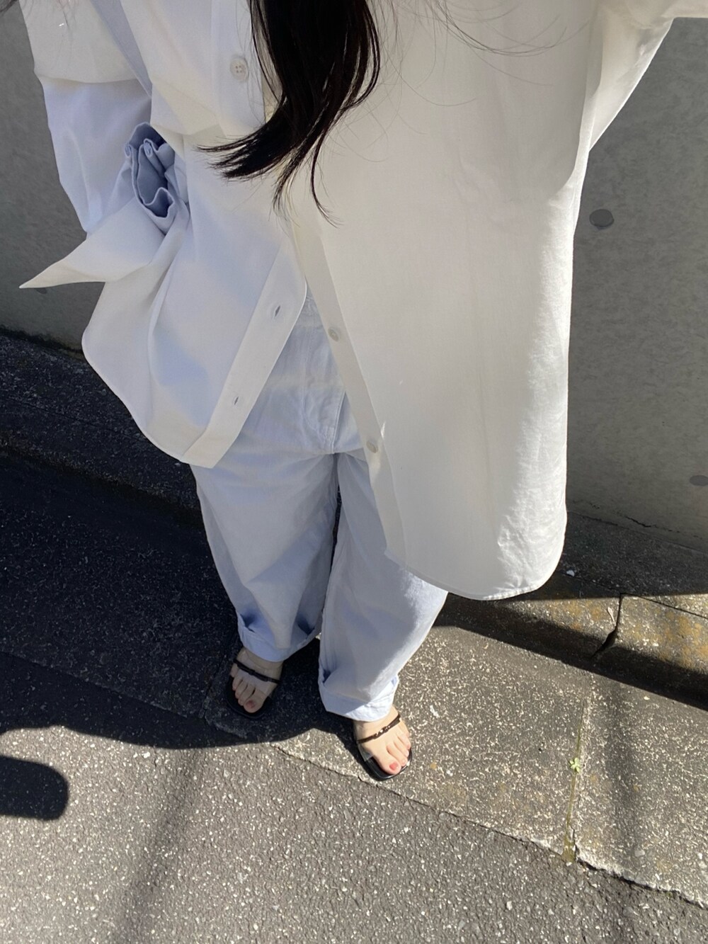 ホワイト系のシャツ/ブラウス、ホワイト系のトートバッグ、ブルー系のデニムパンツを着用したレディースの春コーディネートの6枚目の写真