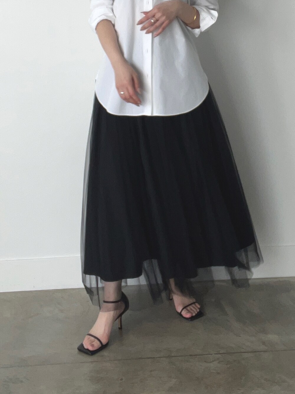 ブラック系のスカート、ホワイト系のシャツ/ブラウスを着用したレディースの春コーディネートの3枚目の写真