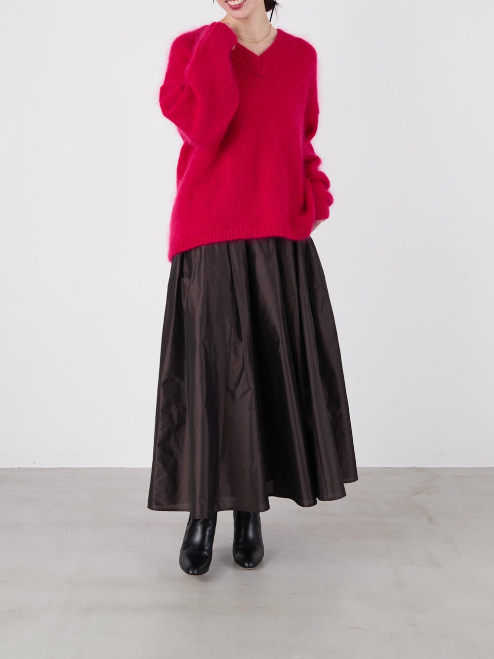 ピンク系のニット/セーター、ブラック系のスカートを着用したレディースの冬コーディネートの3枚目の写真