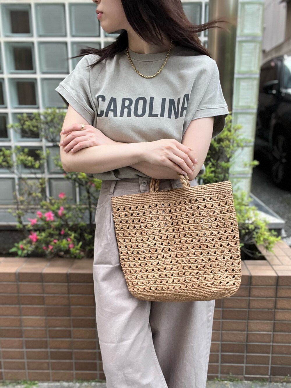 ベージュ系のデニムパンツ、ベージュ系のTシャツ/カットソー、ブラウン系のハンドバッグを着用したレディースの夏コーディネートの5枚目の写真