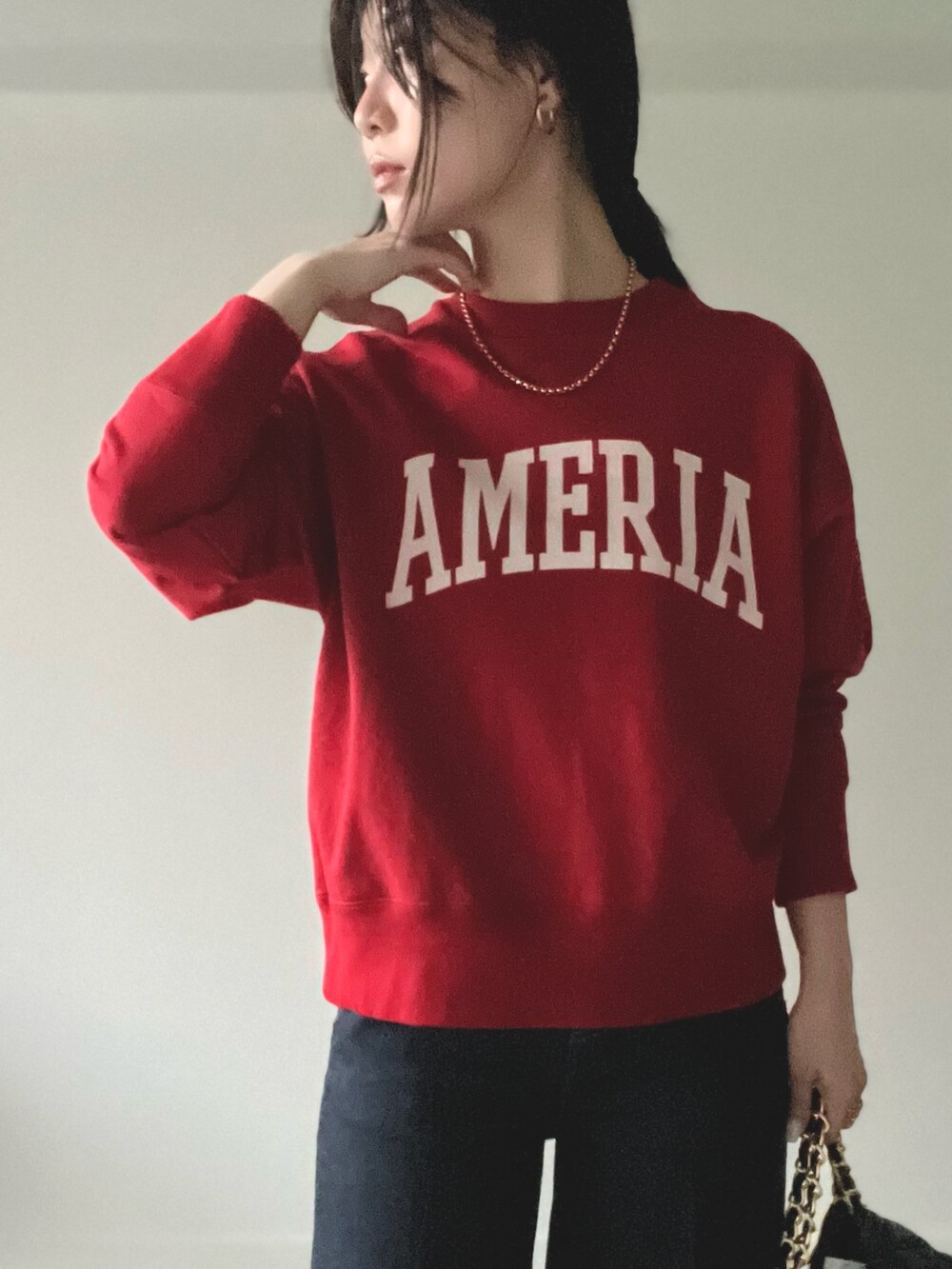 レッド系のスウェットを着用したレディースの秋コーディネートの5枚目の写真