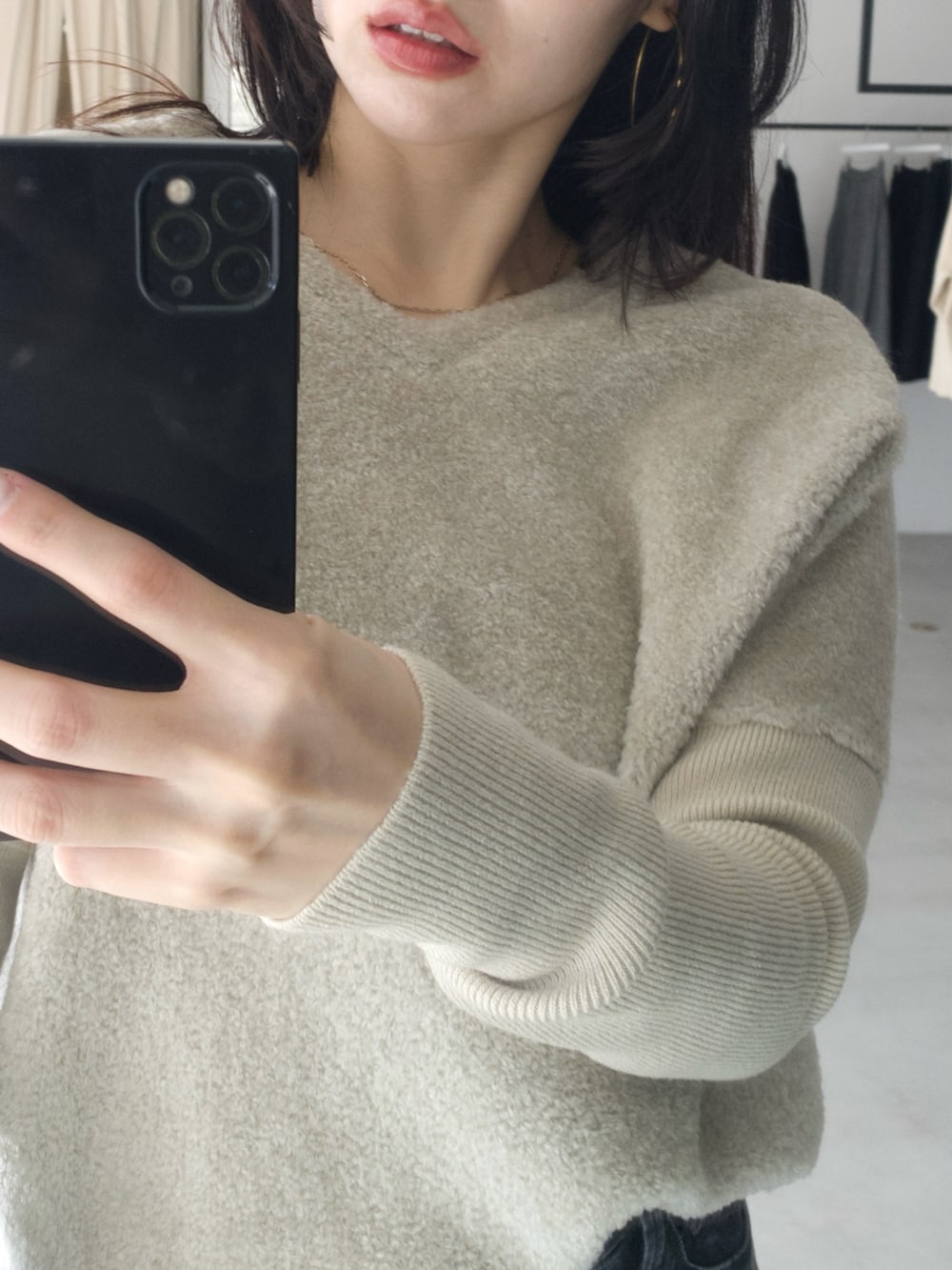 グレー系のニット/セーター、ブラック系のボストンバッグ、グレー系のデニムパンツを着用したレディースの冬コーディネートの4枚目の写真