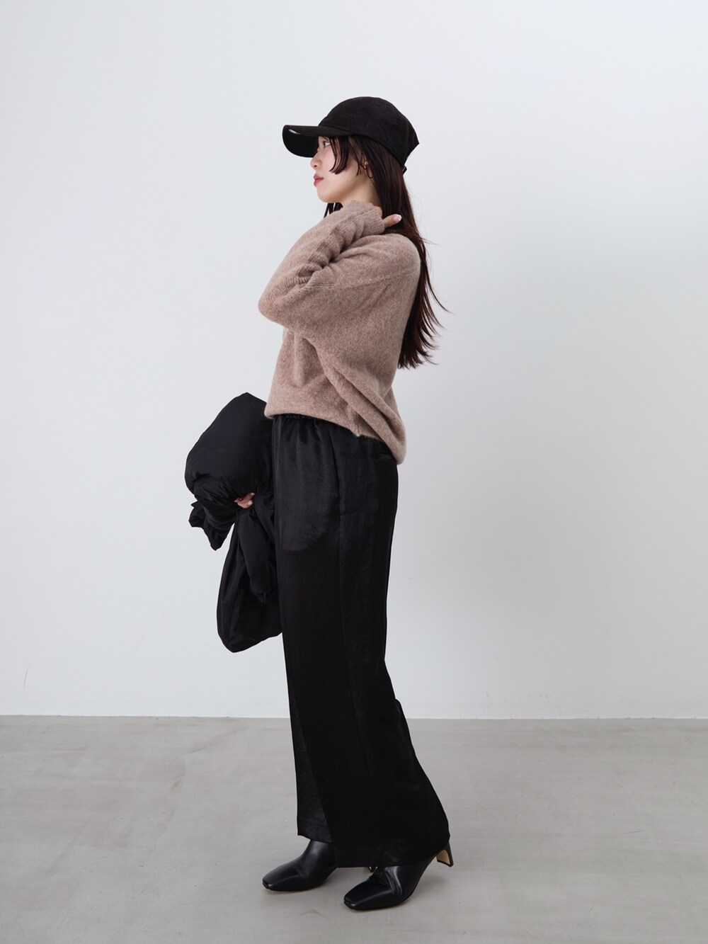 ブラック系のその他パンツ、ブラック系のダウンジャケット/コート、ブラウン系のニット/セーターを着用したレディースの冬コーディネートの3枚目の写真