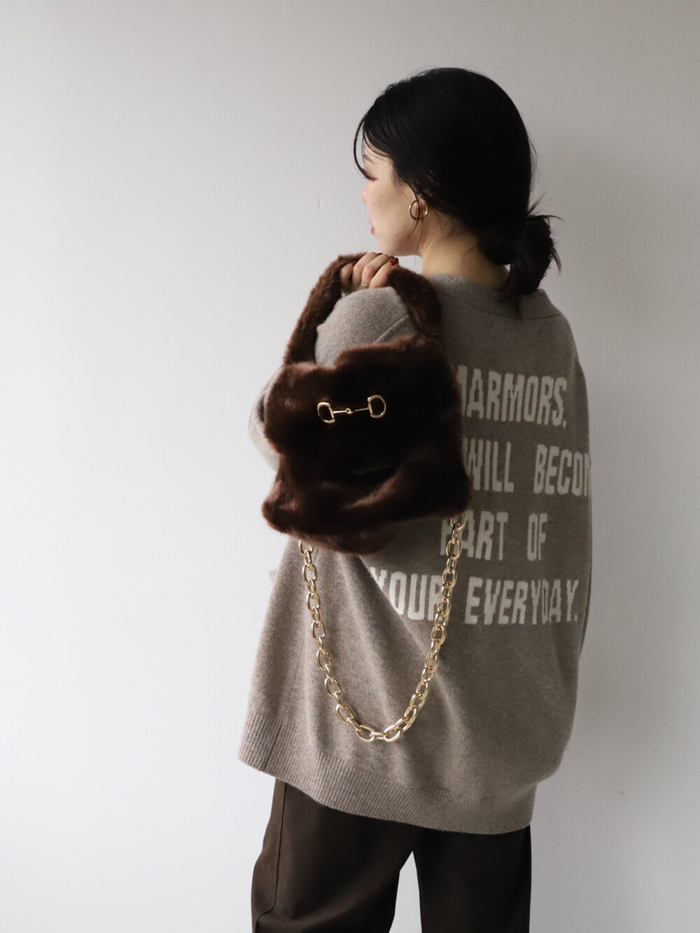 ブラウン系のカーディガン/ボレロ、ブラウン系のその他パンツ、ブラウン系のハンドバッグを着用したレディースの秋コーディネートの3枚目の写真