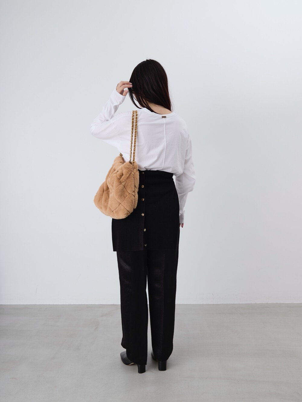 ベージュ系のショルダーバッグ、ホワイト系のTシャツ/カットソー、ブラック系のカーディガン/ボレロを着用したレディースの冬コーディネートの6枚目の写真