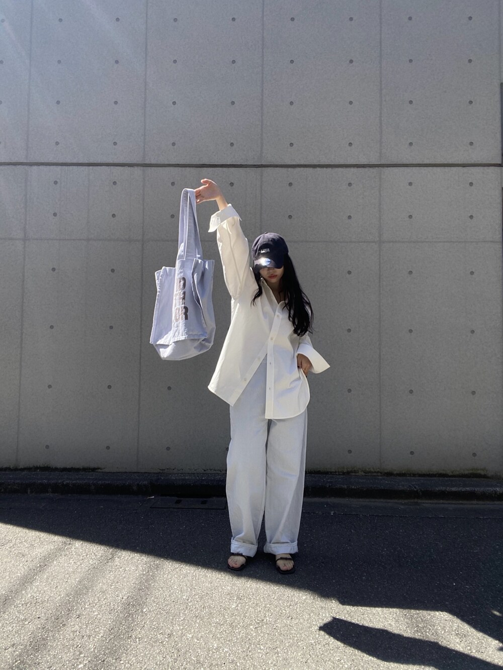 ホワイト系のシャツ/ブラウス、ホワイト系のトートバッグ、ブルー系のデニムパンツを着用したレディースの春コーディネートの7枚目の写真