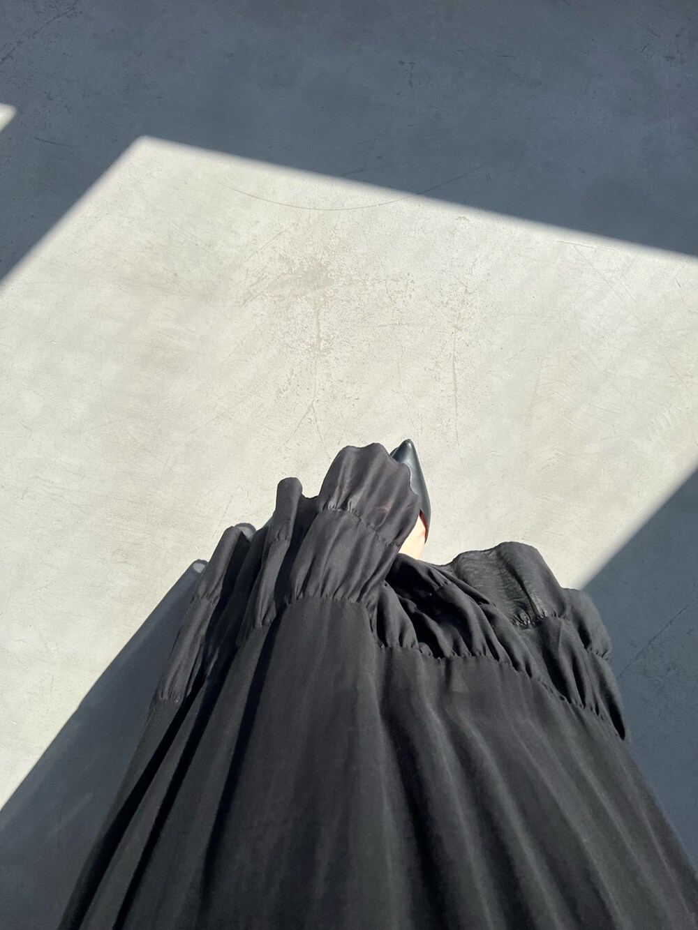 ブラック系のスカート、シルバー系のタンクトップ、ブラック系のカーディガン/ボレロを着用したレディースの春コーディネートの6枚目の写真